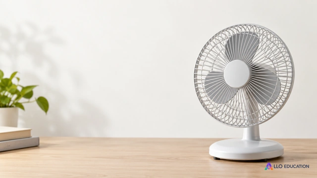 Un petit ventilateur de bureau aux pales visibles derrière une grille, sur un fond clair.
